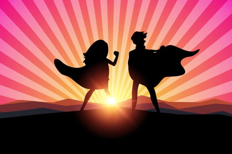 Cartoon silhuettes of female and male superheroes in sunset