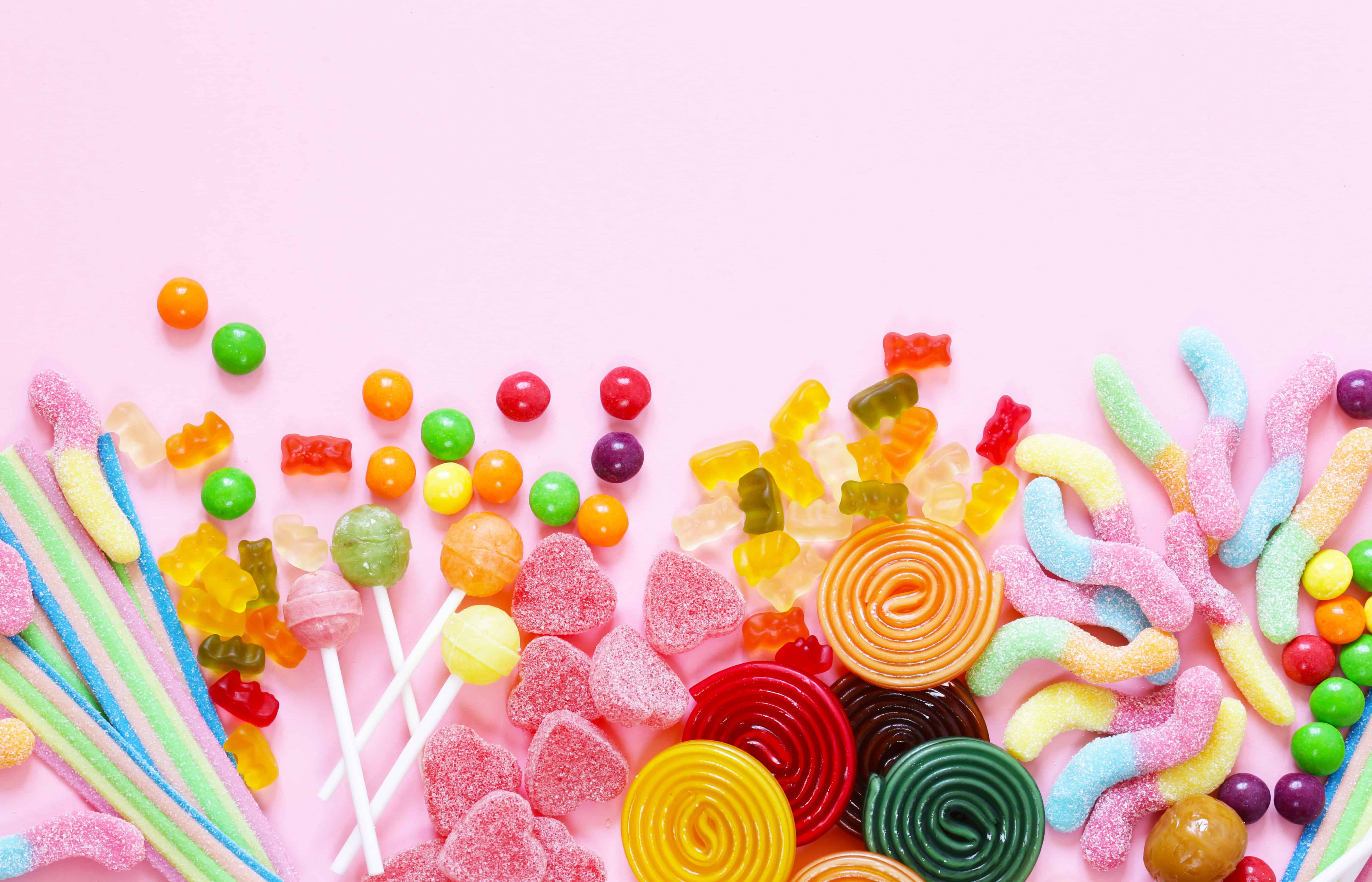 Colorful candy and fruit jelly jujube on a pink background
