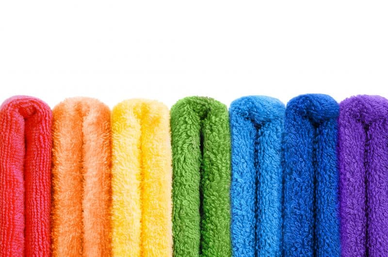 Rainbow colored range of towels on white