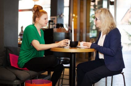 Woman sitting on a Heather at a cafe