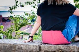 A woman sitting on the heated pad Heather with an amazing view over Visby and the sea.