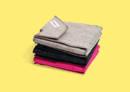 Stapel av 3 ihopvikta Heather i färgerna beige, black och pink. Gul bakgrund.
