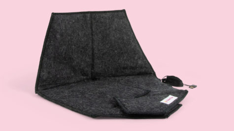 Dynan Heather black uppfälld så man ser att den värmer både rumpa och rygg. Rosa bakgrund.